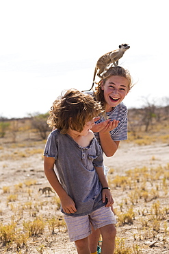 5 year old boy with Meerkat on his head, Kalahari Desert, Makgadikgadi Salt Pans, Botswana