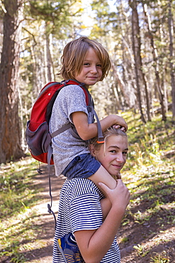 4 year old boy getting ride on sister's shoulders