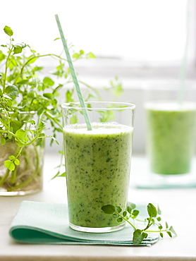 Two glasses of a healthy green smoothie herb drink with a straw, Maryland, USA