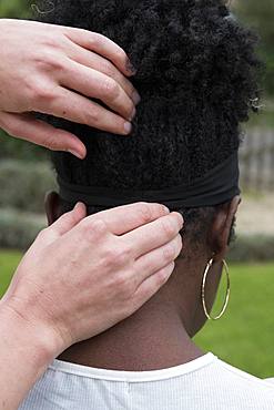 Therapist touching a client's head and neck, in an outdoor therapy session