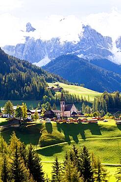 Church in the Val di Funes, alpine valley and mountains in cloud, South Tyrol, Italy