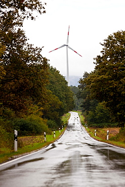 Wind turbine and wet straight road nr Trier, in the Moselle wine region, Germany