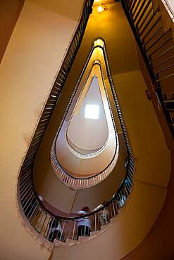 People ascending a spiral stair, view from below.