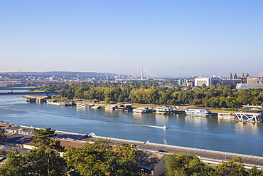 View of floating bars and nightclubs on Sava River, New Belgrade with Ada bridge in the distance, Belgrade, Serbia, Europe