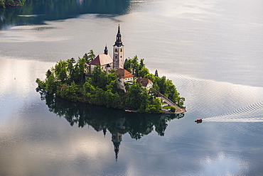 Lake Bled boat (Pletna) approaching Lake Bled Island at sunrise, Gorenjska, Slovenia, Europe