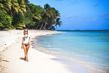 Woman walking along a tropical beach, Rarotonga Island, Cook Islands, South Pacific, Pacific