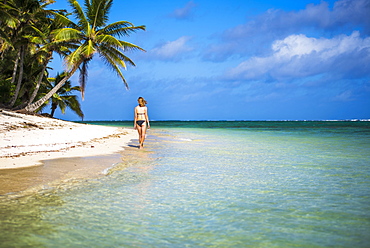 Woman walking along a tropical beach, Rarotonga Island, Cook Islands, South Pacific, Pacific