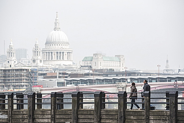 Couple on a pier overlooking St. Paul's Cathedral on the banks of the River Thames, South Bank, London, England, United Kingdom, Europe