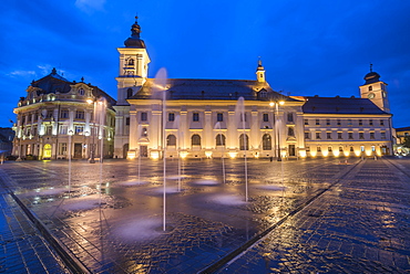 Piata Mare (Great Square) at night, with Sibiu City Hall on left and Sibiu Baroque Jesuit Church on right, Transylvania, Romania, Europe