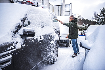 Removing snow from a car, Cairngorms National Park, Scotland, United Kingdom, Europe