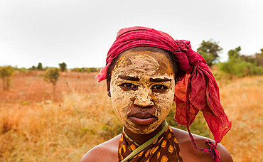 Portrait of young woman wearing dry mud, used to preserve the skin and protect from the sun, Isalo, Madagascar, Africa