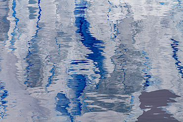 Reflections of icebergs in the calm water photographed from an expedition ship operating in Antarctica, Southern Ocean.