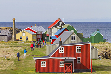 Tourists inspect remote Flatey Island, Iceland.