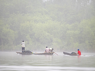 Local people in a traditional dugout wooden boat deep within the Pacaya Samiria Preserve, Peru.