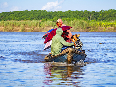 Local people in a traditional dugout wooden boat deep within the Pacaya Samiria Preserve, Peru.