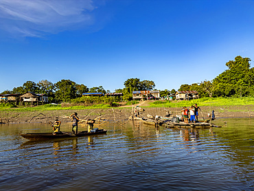 Local people in a traditional dugout wooden boat deep within the Pacaya Samiria Preserve, Peru.