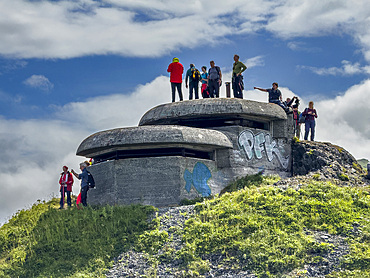 Tourists on top of the remains of World War II bunker left unused in Dutch Harbor, Unalaska, Alaska.