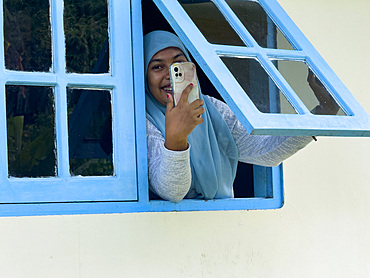Locals woman with a cell phone in the town of Banda Neira on the island of Banda Neira, Moluccas, Indonesia.