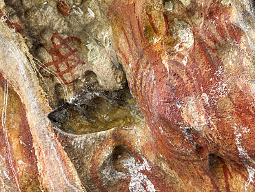 Ancient rock art painted on the limestone cliffs in Berau Bay on the island of Papua, Indonesia.