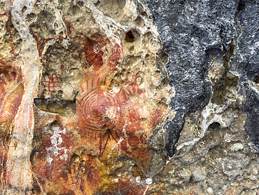 Ancient rock art painted on the limestone cliffs in Berau Bay on the island of Papua, Indonesia.