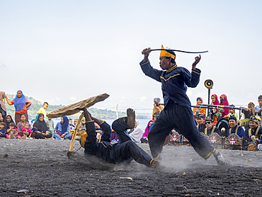 Ceremonial mock fighters perform a ritualized battle with whip, shield, and bow on Sumbawa Island, Indonesia.