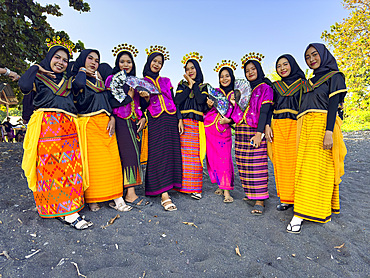 Young women in ceremonial regalia pose for photos on Sumbawa Island, Indonesia.