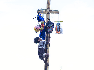 Boys who successfully climbed a greased pole to get to prizes at the top on Sumbawa Island, Indonesia.