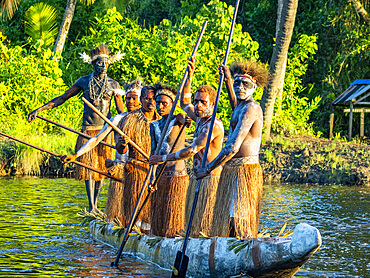 Male paddlers from the village of Uwus perform in a ritualistic greeting ceremony, Asmat Region, Papua, Indonesia.