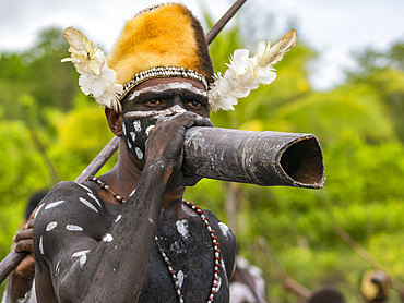 Male paddler from the village of Uwus perform in a ritualistic greeting ceremony, Asmat Region, Papua, Indonesia.