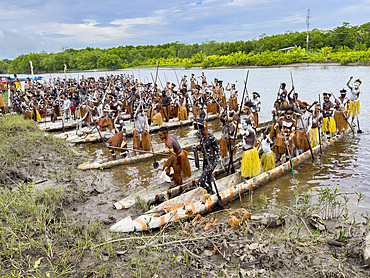 Male paddlers from the village of Uwus perform in a ritualistic greeting ceremony, Asmat Region, Papua, Indonesia.
