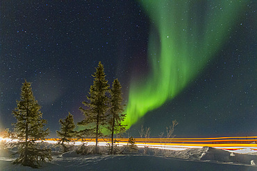 Long exposure of Jeep lights and Aurora Borealis, on the Great Slave Lake, Northwest Territories, Canada.