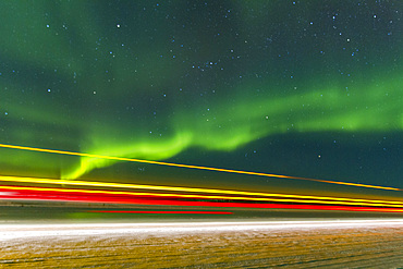 Long exposure of Jeep lights and Aurora Borealis, on the Great Slave Lake, Northwest Territories, Canada.