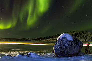 Long exposure of Jeep lights and Aurora Borealis, on the Great Slave Lake, Northwest Territories, Canada.