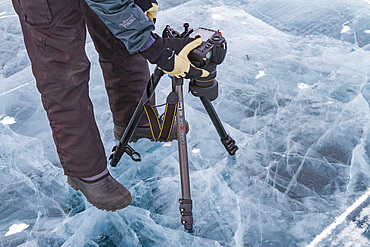 Canadian photographer Gilles Pucheu on the frozen solid Great Slave Lake, Northwest Territories, Canada.