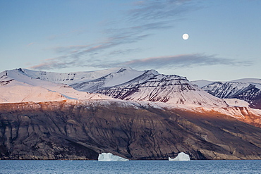 Nearly full moon setting in the early morning near Qilakitsoq, Greenland, Polar Regions