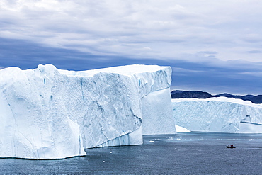 A Zodiac amongst huge icebergs calved from the Ilulissat Glacier, UNESCO World Heritage Site, Ilulissat, Greenland, Polar Regions