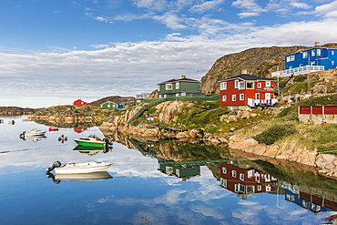 Calm waters reflect the brightly colored houses in Sisimiut, Greenland, Polar Regions