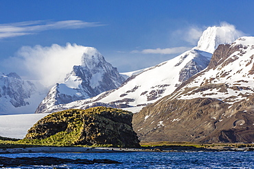 Misty clouds shroud snow-covered peaks in Fortuna Bay, South Georgia, UK Overseas Protectorate, Polar Regions