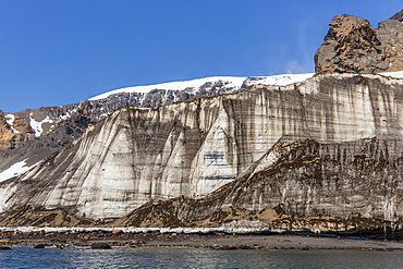 Rust-colored volcanic tuff cliffs above a dark material filled glacier at Brown Bluff, eastern side of the Tabarin Peninsula, Weddell Sea, Antarctica, Polar Regions