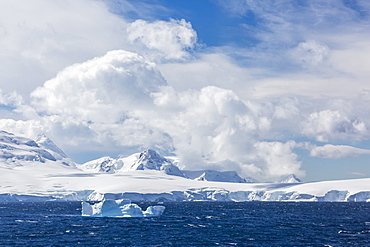 Clouds build over snow-capped mountains in Dallmann Bay, Antarctica, Polar Regions