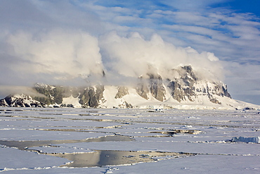 Clouds forming over snow-capped mountains in Penola Strait, Antarctica, Polar Regions