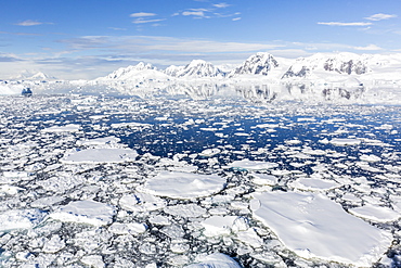 Snow-covered mountains line the ice floes in Penola Strait, Antarctica, Polar Regions