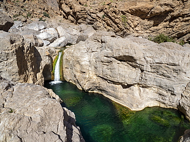 Waterfall dropping in to naturally formed swimming pools in Wadi Bani Khalid, Sultanate of Oman, Middle East