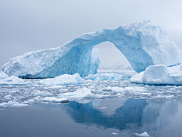 A huge arch formed in a tilted iceberg in Cierva Cove, Antarctica, Polar Regions