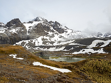 Snow-covered mountains and glacial meltwater lake in Gold Harbor, South Georgia, Polar Regions