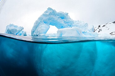 Above and below view of an arch formed in an iceberg at Cuverville Island, Ererra Channel, Antarctica, Polar Regions