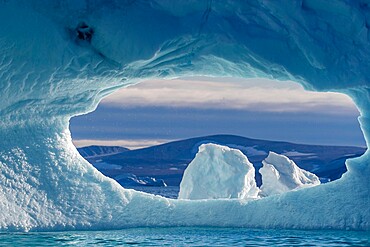 A hole in an iceberg in De Dodes Fjord (Fjord of the Dead), Baffin Bay, Greenland, Polar Regions