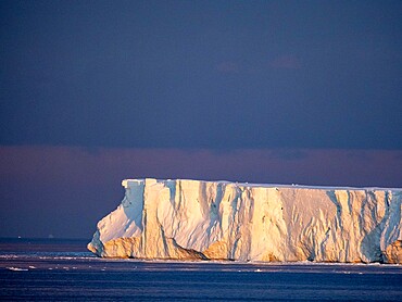 Sunset on a large iceberg at sea towards Peter I Island, Bellingshausen Sea, Antarctica, Polar Regions