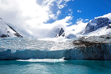 A view of snow-capped mountains and a shooter from the glacier in Drygalski Fjord, South Georgia, South Atlantic, Polar Regions