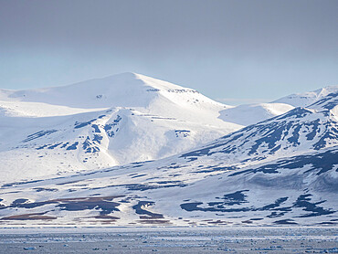 Snow covered mountains and bare rock on the coast of Spitsbergen, Storfjorden, Svalbard, Norway, Europe